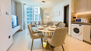 A modern apartment with a dining area, sofa, and kitchen.