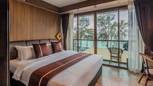 A hotel room with a large bed, a ceiling fan, a view of the beach, and a balcony with chairs. - Syama V Ao Nang Beach Krabi, an Aspira Collection (Krabi)
