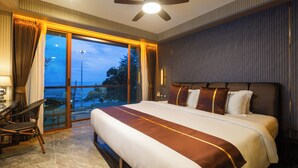 A hotel room with a large bed, a desk, and a chair. There is a balcony with a view of the outdoors. - Syama V Ao Nang Beach Krabi, an Aspira Collection (Krabi)