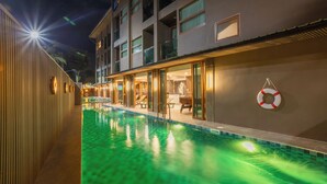 A swimming pool adjacent to a building with balconies and a lifebuoy on the wall. - Syama V Ao Nang Beach Krabi, an Aspira Collection (Krabi)