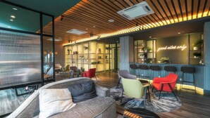 A modern interior with a wooden ceiling, a bar area, and seating arrangements.