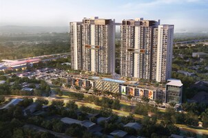 A high-rise residential building with multiple floors, surrounded by greenery and a busy road.