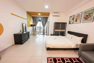 A hotel room with a bed, a dresser, a wardrobe, a chair, and a balcony with curtains.