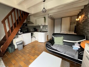 A compact living space with a kitchen, a sofa, a dining table, and a staircase. - House 300m from the beach with parking (Sarzeau)