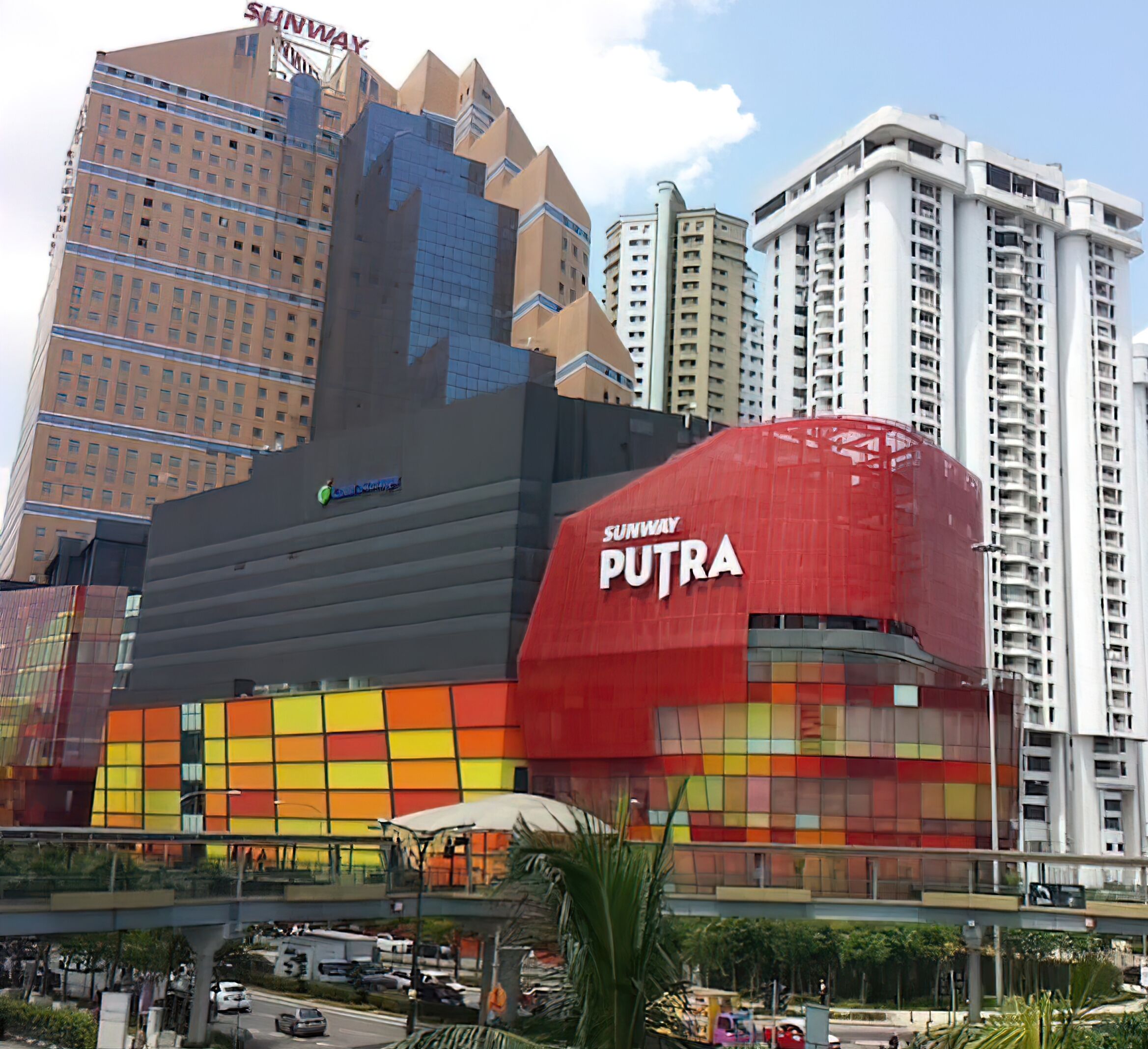 A large, modern building with a distinctive red and yellow facade, labeled 'Sunway Putra'.