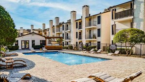 A pool area with lounge chairs and a small building, surrounded by multi-story residential buildings. - Beautiful 1Bd/1Bd Apartment in Dallas (Dallas)