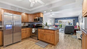 Une cuisine moderne avec des meubles en bois, des appareils en acier inoxydable et un îlot central.