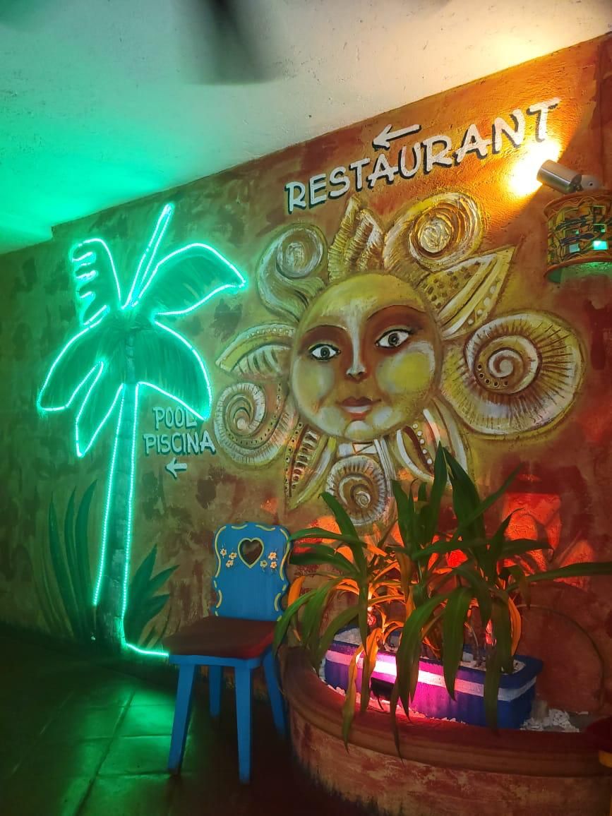 Eine Wand mit einem Neon-Schild für ein Restaurant und einem Pool.