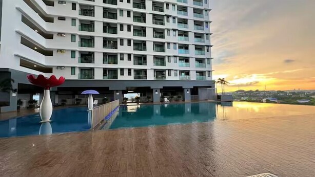 A modern hotel with a rooftop infinity pool, a large decorative sculpture, and a view of the sunset. - Vista Bangi Serviced Apartments by The River (Kajang)