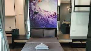 A modern hotel room with a large bed, a desk, and a wall-mounted TV displaying a space-themed image. - Vista Bangi Serviced Apartments by The River (Kajang)