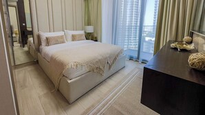 A modern hotel room with a large bed, a bedside table, a mirror, and a view of the city through large windows. - Chic Meydan Apt with Balcony and City & Pool Views-1012 (Dubai)