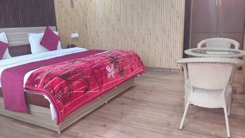 Quarto com cama, mesa de cabeceira, uma cadeira e parede de madeira.