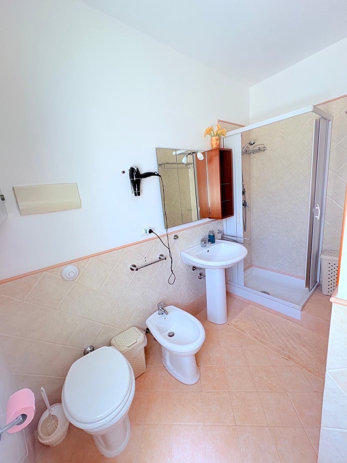 Ein Badezimmer mit Toilette, Bidet, Waschbecken und Dusche.