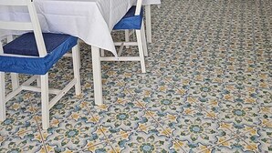 A dining area with a tiled floor, white chairs, a table with a blue tablecloth, and a white cabinet with a mirror. - Perla Bianca Holiday Home Ischia, Forio, nei pressi dei giardini Poseidon (Forio, Ischia (Na))