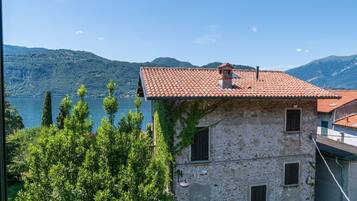 Un edificio in pietra con tetto in tegole rosse, un piccolo camino e una finestra.
