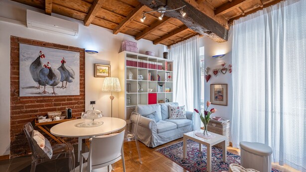 Un salon chaleureux avec une table à manger ronde, un canapé et une bibliothèque.