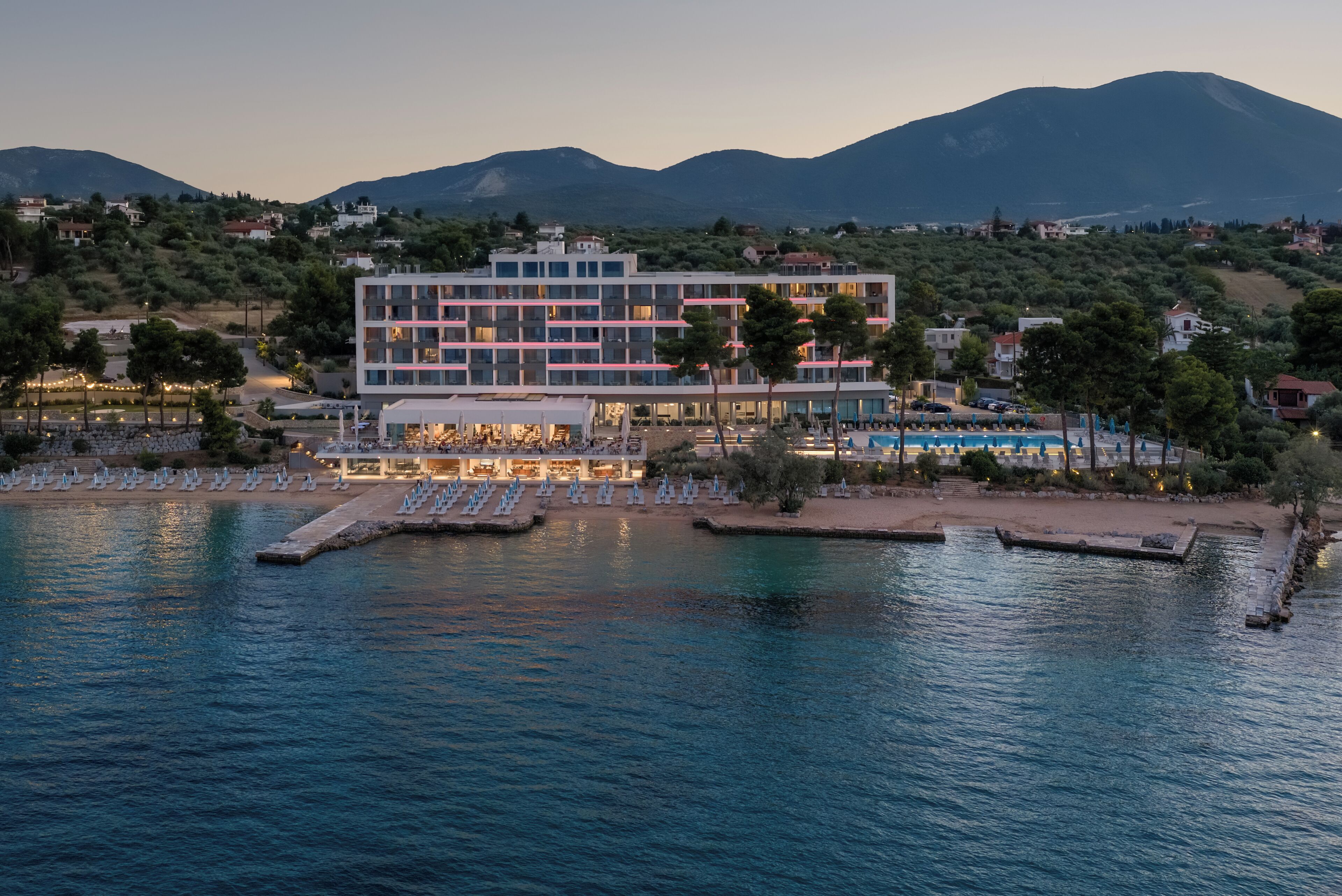 Un hôtel doté d’une piscine, de plusieurs étages et offrant une vue sur les montagnes en arrière-plan.