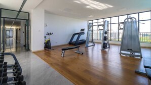 A spacious gym with cardio equipment, weight machines, and a bench. - Upperhill View Palace Apartment (Nairobi)