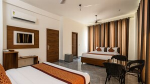 A hotel room with two beds, a TV, a desk, and a chair. - Hotel Yash Regency - Managed by JMD Group (New Delhi)
