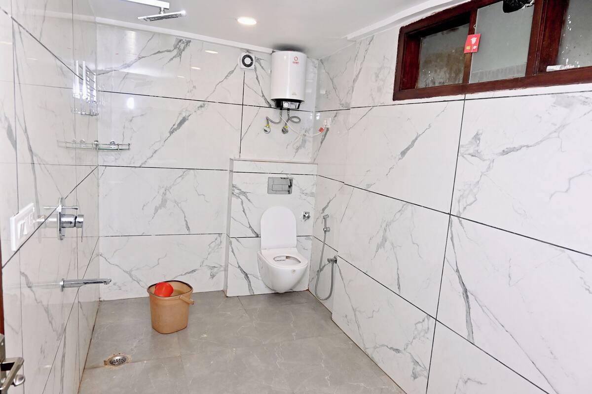Un baño con inodoro, ducha y secador de manos.