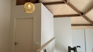 A room with a white door, a woven pendant light, and a wooden ceiling structure. - Luxury Hay Barn Holiday Home with Open Countryside Views in the Green Heart (Alphen aan den Rijn)