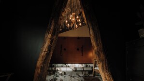 Una escalera de madera rústica que lleva a un cuarto con candelabro.
