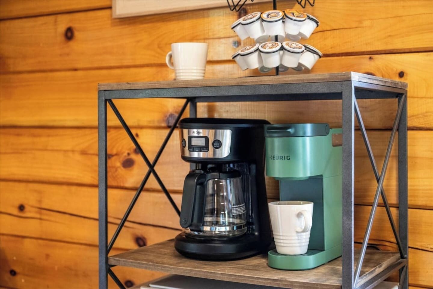 A coffee maker and a mug on a shelf.