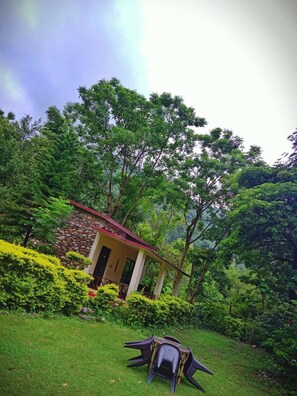 A small stone building with a red roof surrounded by lush greenery. - The Harikanta Corbett Resort (Marchula)