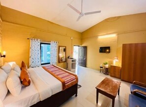A bedroom with a bed, bedside table, and a ceiling fan. - The Harikanta Corbett Resort (Marchula)