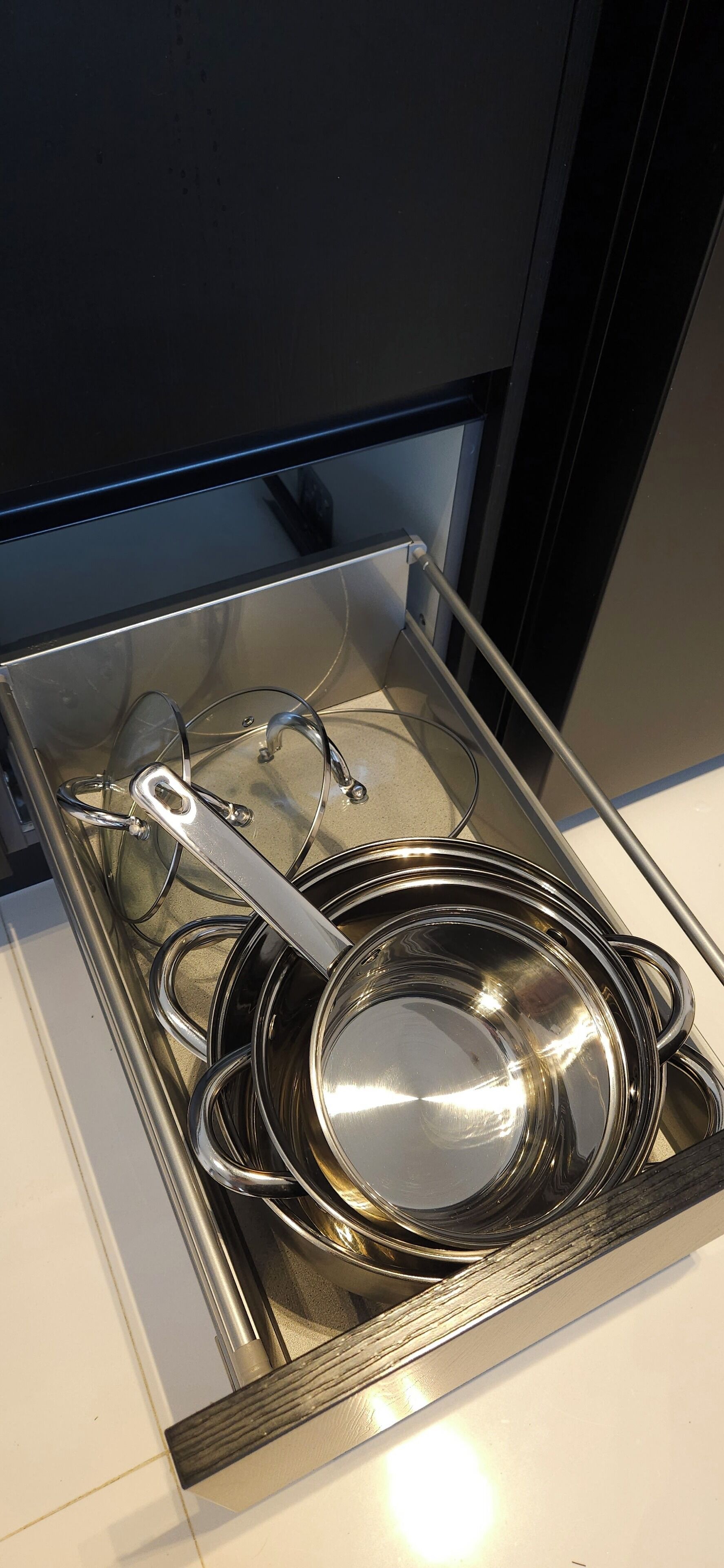 Un cassetto cucina in acciaio inossidabile con pentole e padelle.