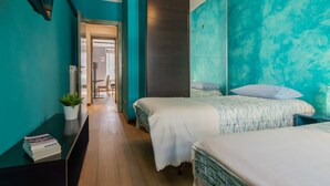 Un dormitorio con dos camas, un escritorio y un espejo.