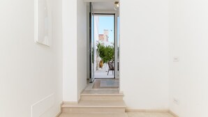 Un pasillo limpio y moderno con una puerta de cristal que da a un espacio exterior.