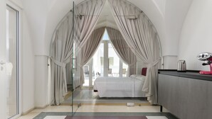 Una habitación de hotel con cama, escritorio y vistas a través de un ventanal.