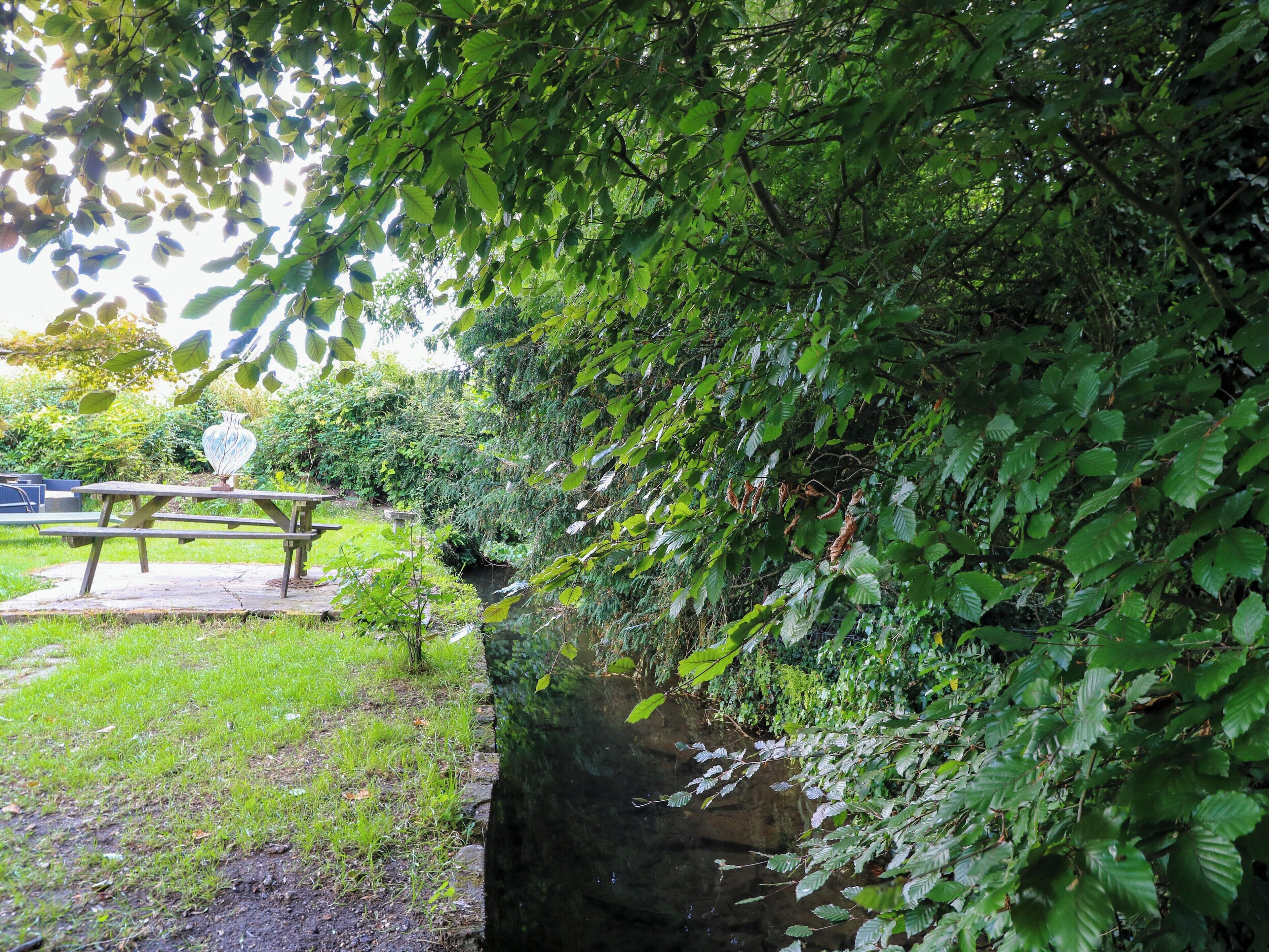 A park with a picnic table and a stone wall.