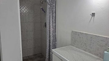 A bathroom with a shower, a sink, and a toilet.