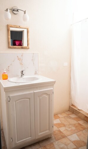 A bathroom with a white sink, a mirror, and a shower curtain.
