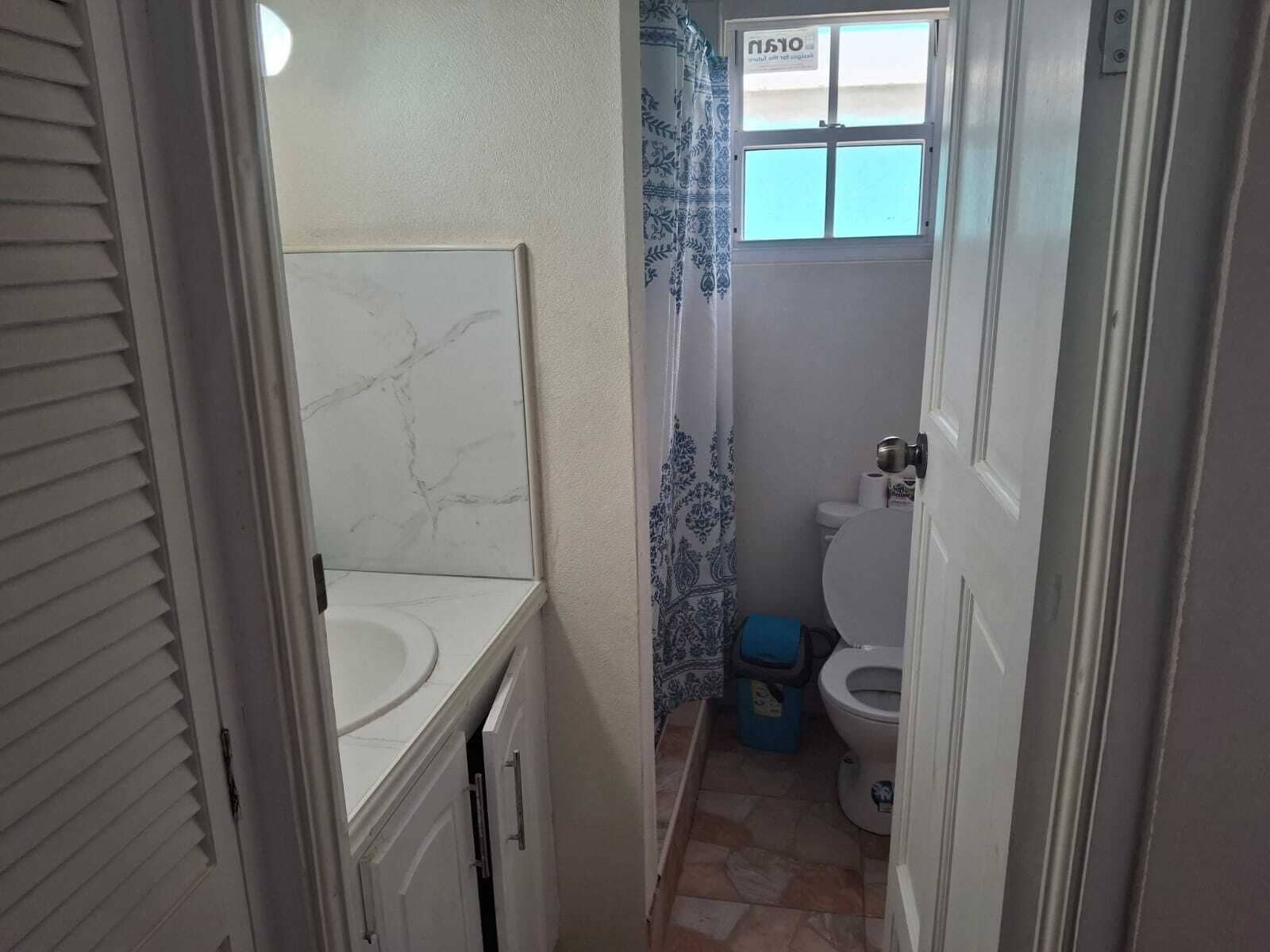 A bathroom with a white sink, a toilet, and a shower curtain.