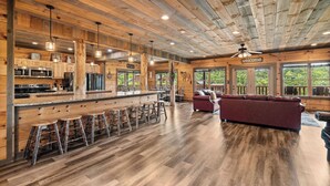 Une cuisine spacieuse avec des meubles en bois, un îlot central doté de tabourets et un coin bar.