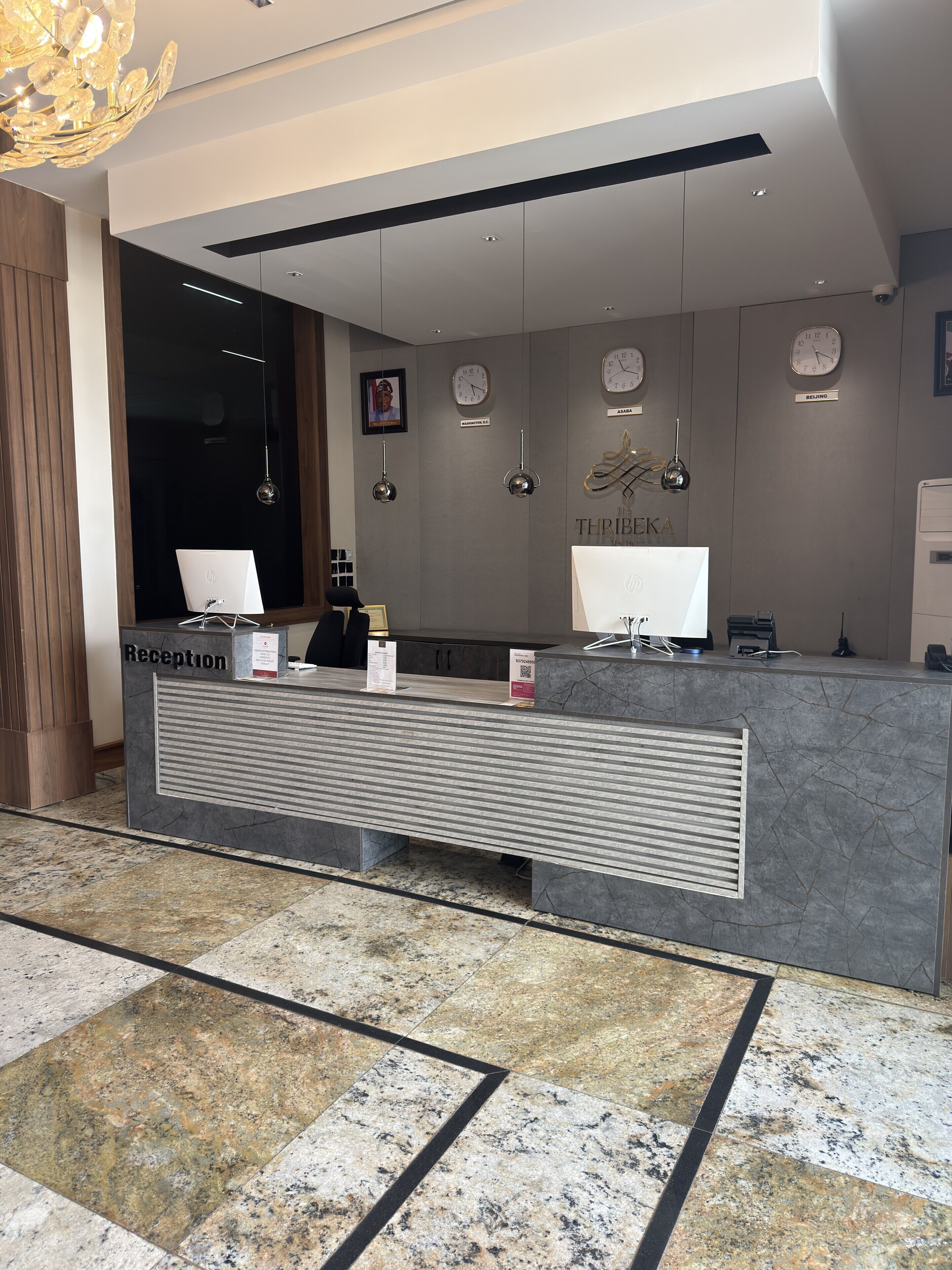 A reception desk with a modern design, a clock, and a framed picture on the wall.
