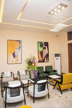A modern lobby with a seating area, artwork, and a chandelier. - THE THRIBEKA INTERNATIONAL HOTEL (Asaba)