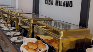 Un buffet avec des récipients étiquetés pour différents types d’aliments, un logo encadré au-dessus et un sol en marbre.
