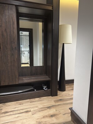 A modern bathroom with a dark wood vanity, a mirror, and a floor lamp. - THE THRIBEKA INTERNATIONAL HOTEL (Asaba)