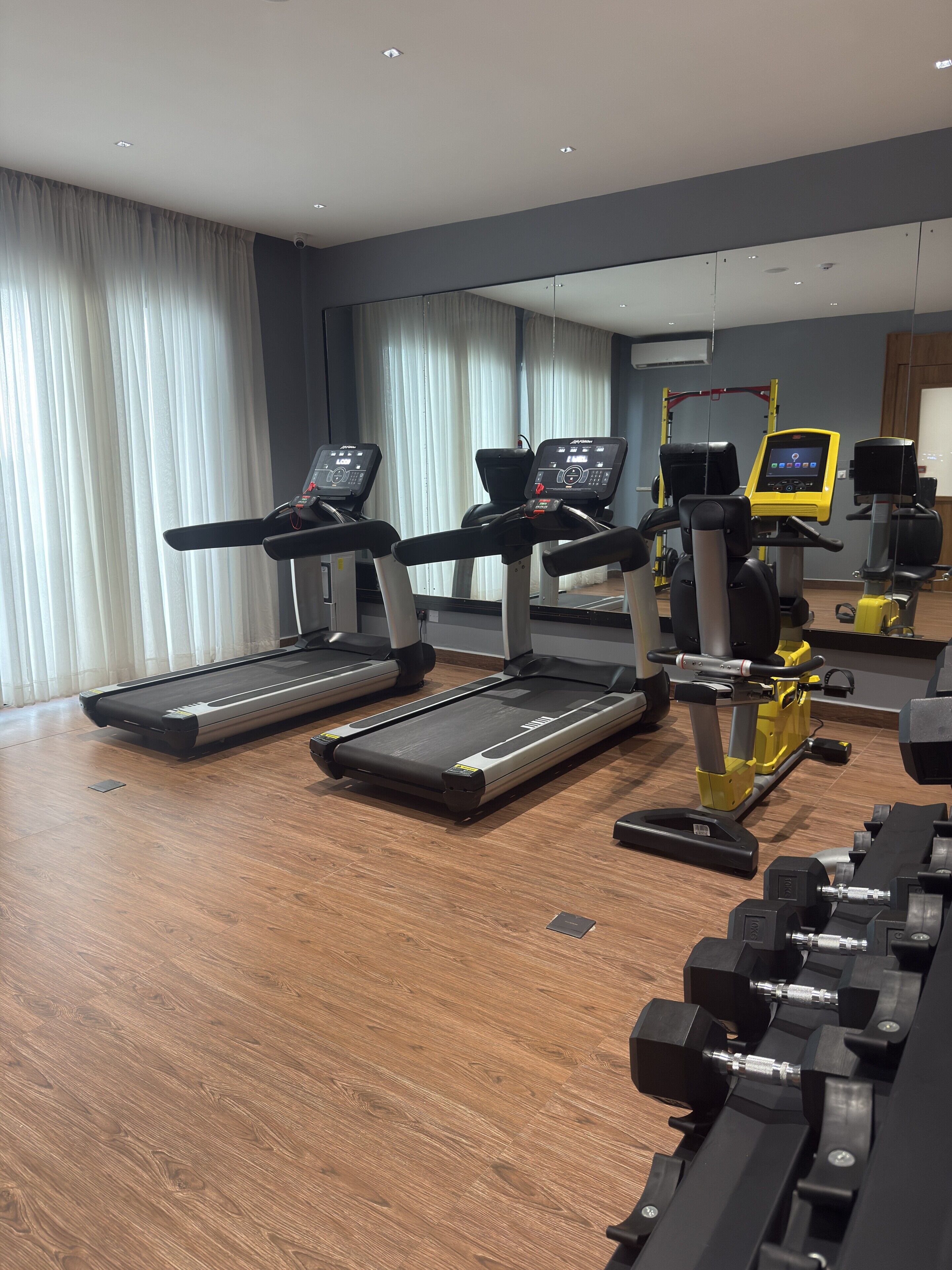 A gym with treadmills, a weight bench, and exercise equipment.
