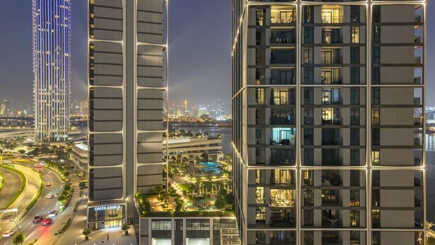 A high-rise building with multiple floors, large windows, and a well-lit facade. - Stylish 2BR — Creek Harbour Views Near Yacht Club & Dining Spots (Dubai Creek Harbour)