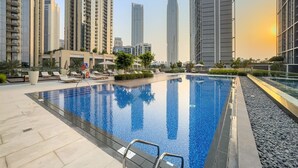 A rooftop swimming pool with a clear view of surrounding high-rise buildings. - Stylish 2BR — Creek Harbour Views Near Yacht Club & Dining Spots (Dubai Creek Harbour)