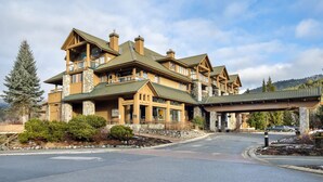 A large lodge with multiple stories, stone and wooden exterior, and a covered entrance.