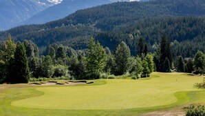 A golf course with a mountainous backdrop.