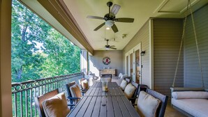 Un patio techado con una mesa y sillas, una hamaca colgante y una chimenea.