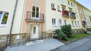 A multi-story residential building with a light-colored facade, multiple windows, and balconies with railings. - Nice apartment for 4 guests with WIFI, TV and balcony (Dresden)