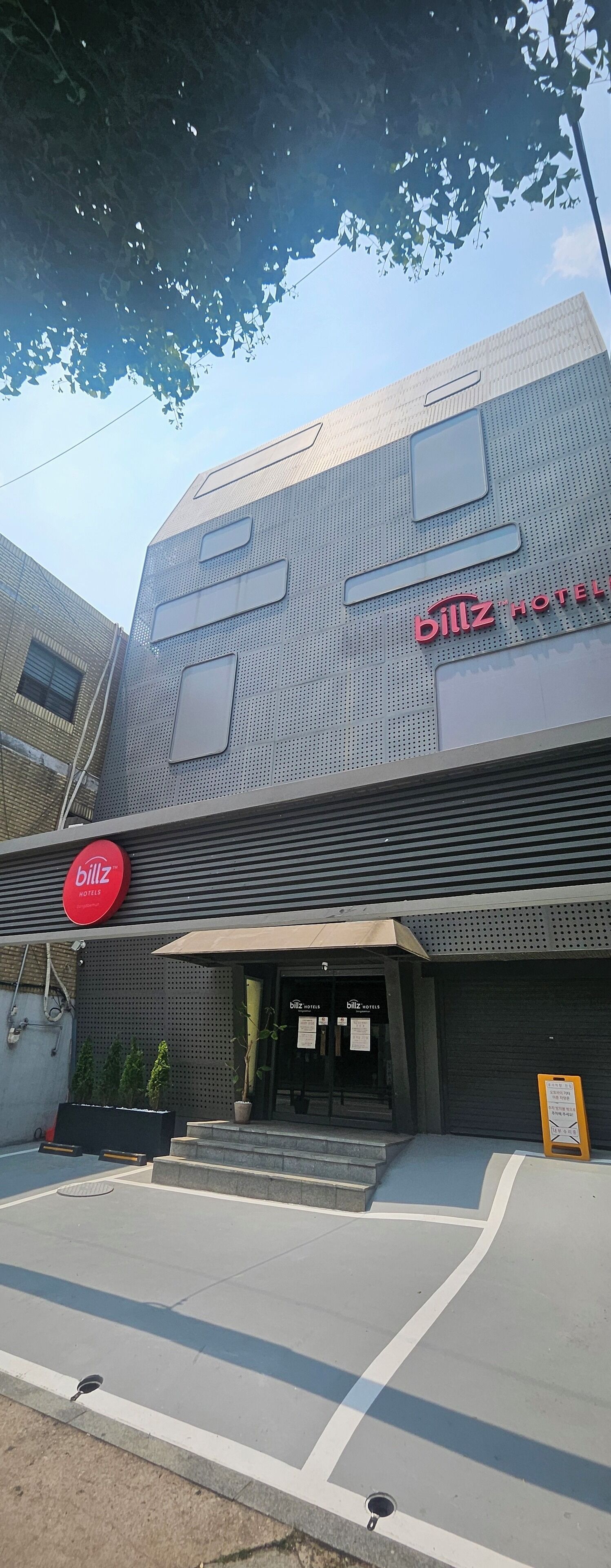 A modern building with a prominent 'Billz Hotels' sign.